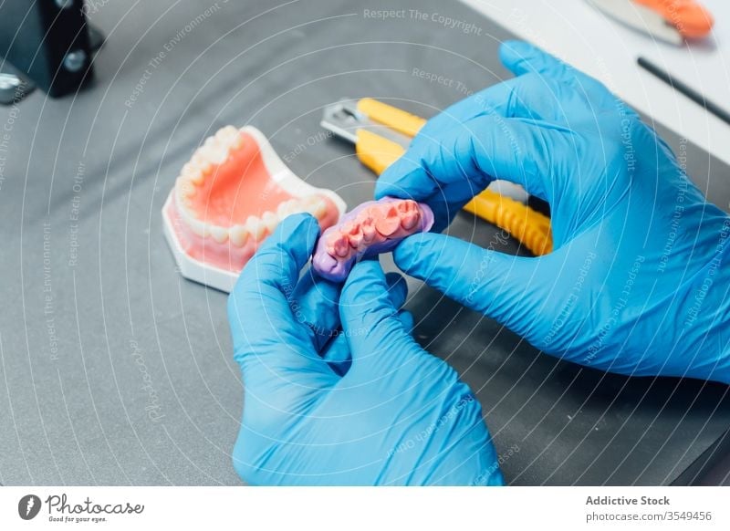 Student arbeitet mit Zahnersatz im Labor dental Prothesen Kiefer Mann lernen Zahnmedizin künstlich kieferorthopädisch Gesundheitswesen Medizin mündlich
