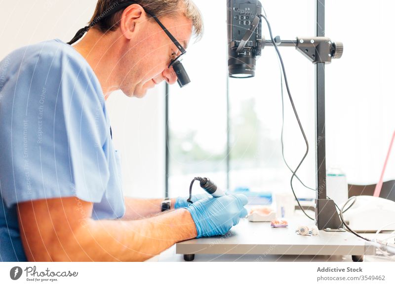 Zahnarzt benutzt Mikroskop während der Arbeit im Klassenzimmer Zahnmedizin lernen Bildung Klassenraum Medizin Gerät Mann Werkzeug Labor professionell Arzt