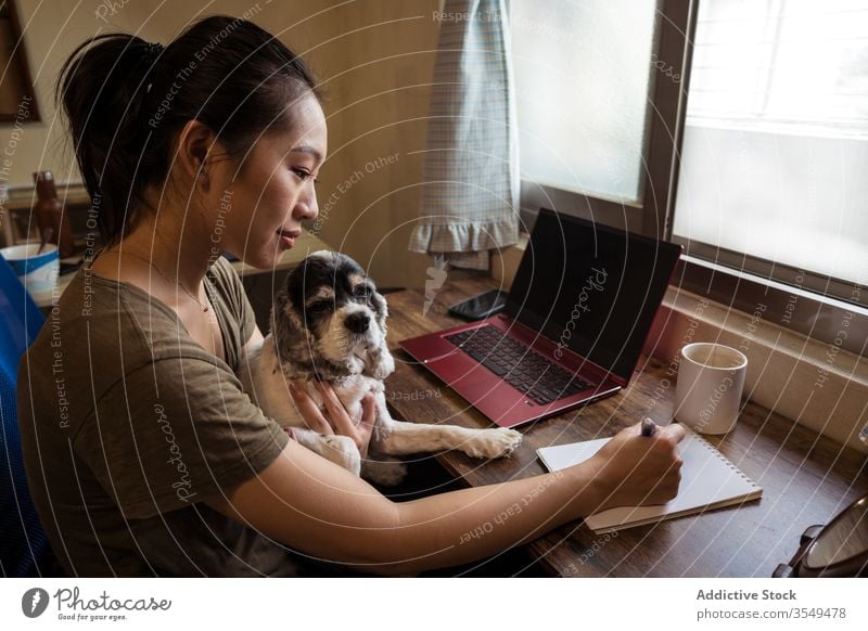 Vielbeschäftigte asiatische Unternehmerin arbeitet im Home Office zu Hause Arbeit Schreibstift Papier Notebook schreibend Frau Projekt Notizblock multitask