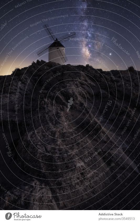 Steiniger Hügel mit holländischer Windmühle in sternenklarer Nacht Landschaft Milchstrasse Berge u. Gebirge Felsen Himmel holländische Windmühle spektakulär