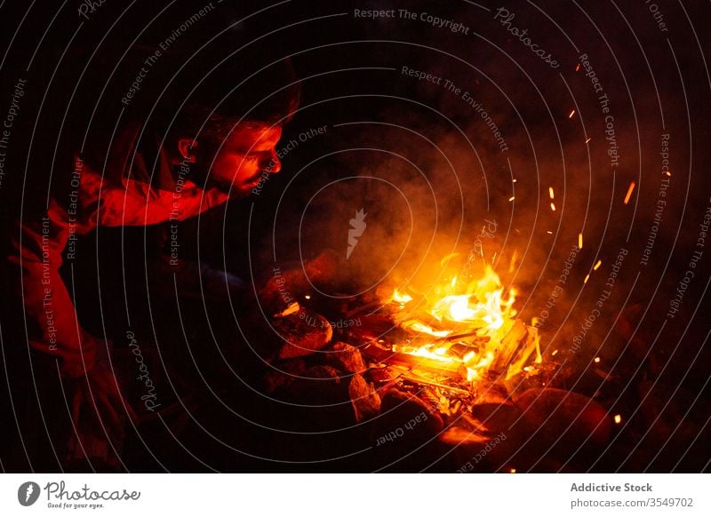 Mann mit Brennholz beim Lagerfeuermachen im Wald Wohnmobil Freudenfeuer Nacht Totholz Aufwärmen männlich Windstille Reisender ruhig Wälder genießen Wochenende