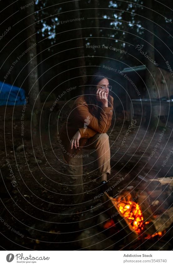 Nachdenkliche reisende Frau wärmt sich am Lagerfeuer im Wald auf Freudenfeuer Wälder besinnlich Wohnmobil Aufwärmen sich[Akk] entspannen nachdenken Abend