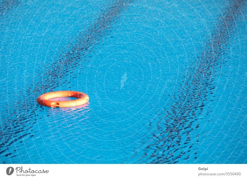 Oranger Rettungsring schwimmt auf einem Teich retten sparen Rettungsschwimmer Gerät Wasser Sicherheit Pool Lifestyle Sommer sonnig blau Leben Schutz Schwimmer