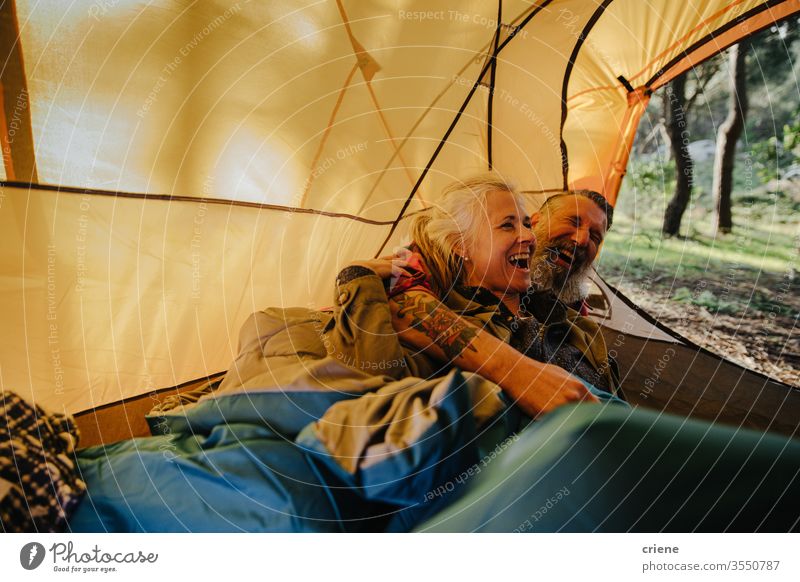 Senior Paar lachend und kuschelnd im Zelt in Bettrolle Lachen Hinlegen Lächeln Schlafsack Glück genießend aktiv Aktivität Tourist Freizeit Feiertag Senioren