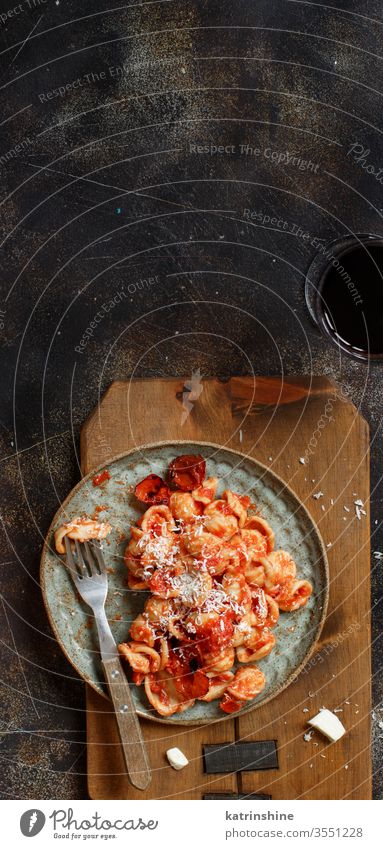 Süditalienische Pasta-Orecchiette mit Tomatensauce und Cacioricotta-Käse Spätzle Italienisch Apulien Saucen sugo Draufsicht dunkel Textfreiraum hölzern gekocht