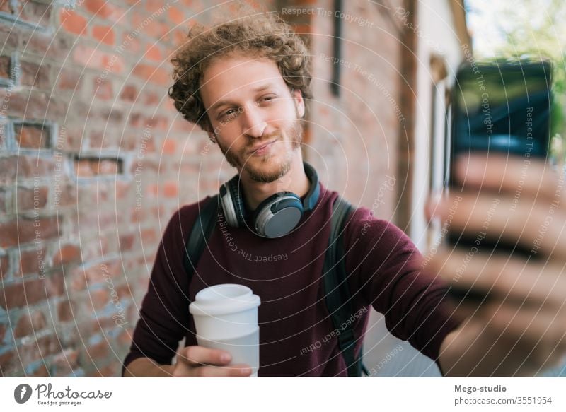Junger Mann nimmt sich selbst mit dem Telefon. Selfie männlich im Freien jung Lächeln eine Menschen Straße Beteiligung Funktelefon Mobile Großstadt urban Selbst