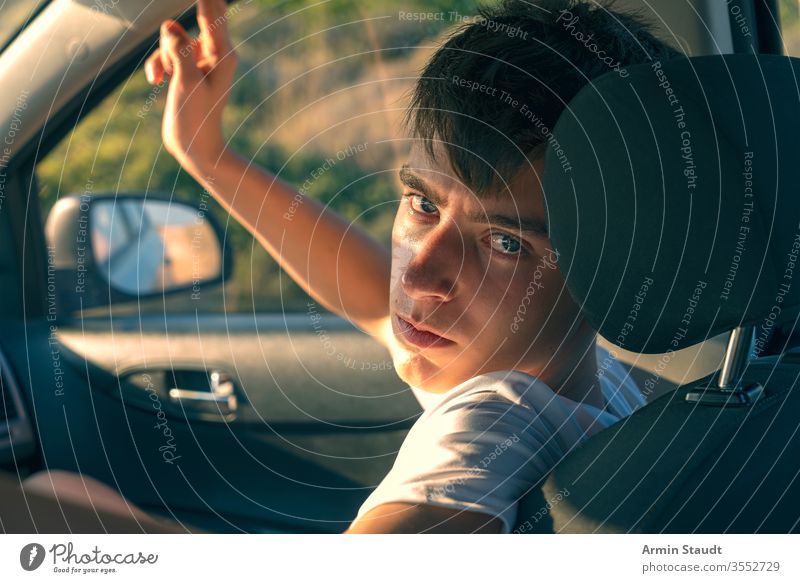 Porträt eines jungen Mannes, der in einem Auto sitzt Rücken schön Junge PKW lässig Kaukasier Beifahrer selbstbewusst cool Laufwerk Auge Kopfstütze