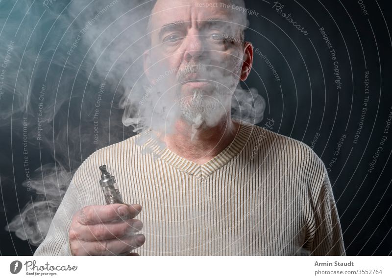 Porträt eines Mannes mit Bart, der sich gerade windet Hintergrund Vollbart blasend Unschärfe Zigarette Zigaretten cool E-Zigarette ecig elektronisch Gerät