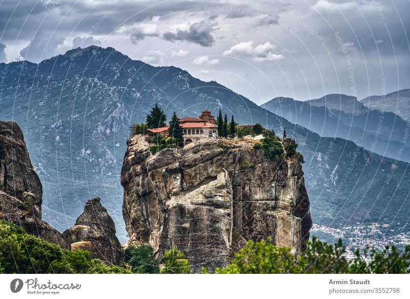 Kloster auf einem riesigen Felsen in Meteora, Griechenland mit Bergkette und dramatischen Wolken Abtei Kirche Klippe Kultur Architektur Anziehungskraft schön
