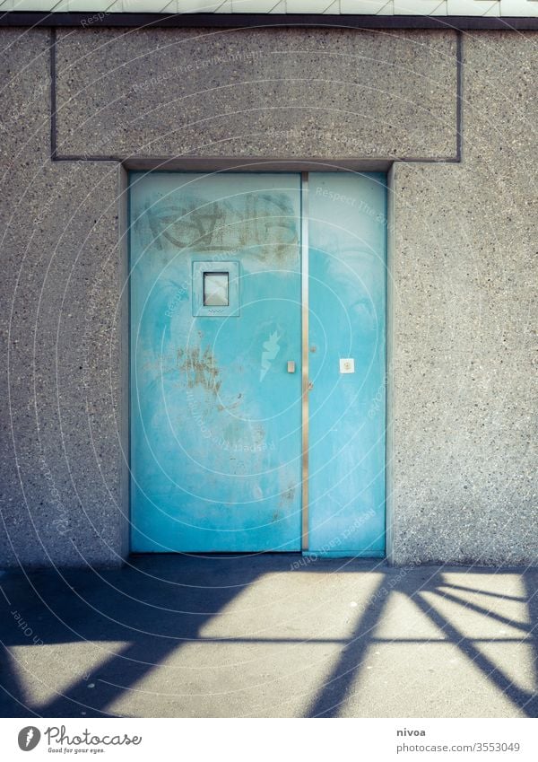 Tür Schatten türkis blau Metall Wand Fenster zugeklappt weiß Eingang Haus Menschenleer Farbfoto Außenaufnahme Mauer Tag Gebäude Fassade trist grau Stadt