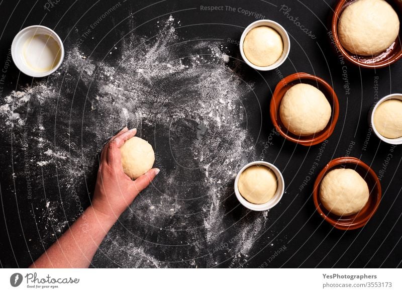 Brötchen backen - Ansicht von oben. Frau formt Brotteig obere Ansicht gebacken Bäcker Bäckerei schwarzer Hintergrund Keramikschalen Komfortnahrung