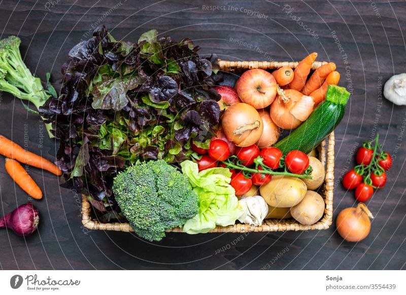 Frische regionale Obst und Gemüsekiste auf einem braunen Holztisch, Draufsicht Bioprodukte Vegetarische Ernährung frisch Gesundheit Obst- oder Gemüsestand
