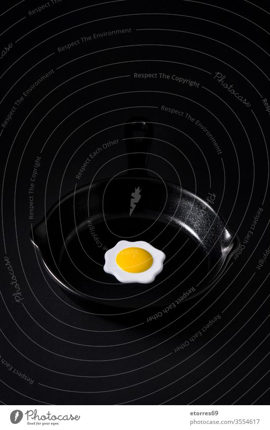 Schwarze Bratpfanne mit Ei innen auf schwarzem Hintergrund Konzept Geschirr getrocknet leer Lebensmittel bügeln vereinzelt Küche Minimalismus Attrappe Objekt