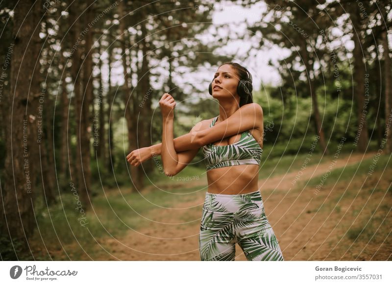 Junge Frau, die sich mitten im Wald beim Sport streckt und frische Luft atmet jung Übung Fitness Lifestyle Training Gesundheit Person Erwachsener sportlich