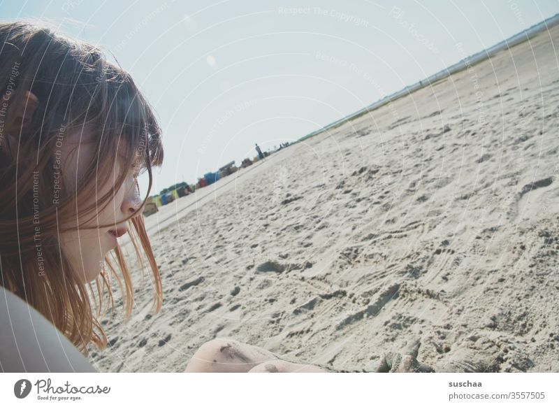 jugendliche sitzt an einem strand bei ebbe mit schiefem horizont Jugendliche Teenager Profil Gesicht Haare sitzen Sommer Sonne Strand Sand Meer Nordsee Ebbe