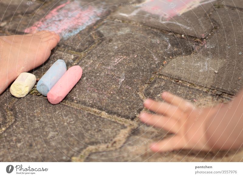 Zwei Kinder malen mit Straßenkreide. Kinderhand und Kinderfuß straßenkreide spiel kreativ hsbd bunt farben Kreativität Kindheit Freizeit & Hobby Spielen Freude