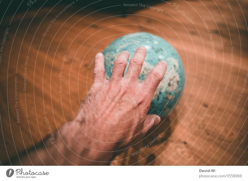 nach der Welt greifen - Hand greift nach einem Globus Größenwahn Mann Corona verbessern Ziel Geografie Weltreise Reiseziel Urlaub planung Urlaubsstimmung