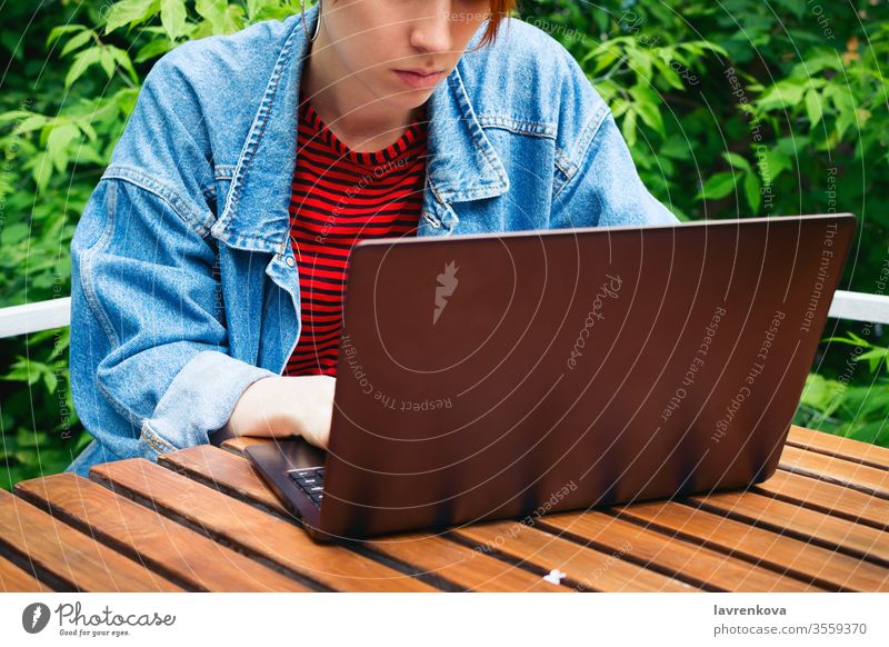 Nahaufnahme-Porträt einer jungen erwachsenen Freiberuflerin, die draußen an ihrem Laptop arbeitet Schüler online Job Erwachsener Sitzen Frau im Freien Internet