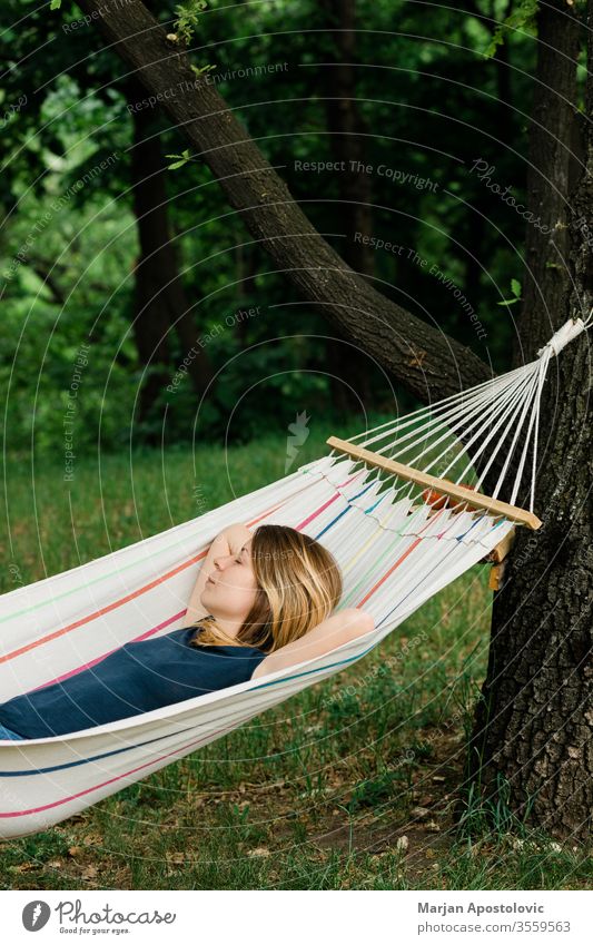 Junge Frau entspannt sich in der Hängematte in der Natur Erwachsener allein Hinterhof Windstille sorgenfrei lässig bequem Landschaft Tag träumen leicht genießen