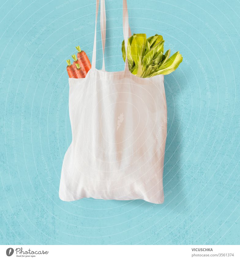 Weiße Textil-Einkaufstasche mit Gemüse auf hellblauem Hintergrund. Null-Abfall.  Wiederverwendbar. Umweltfreundlich keine Verschwendung weiß