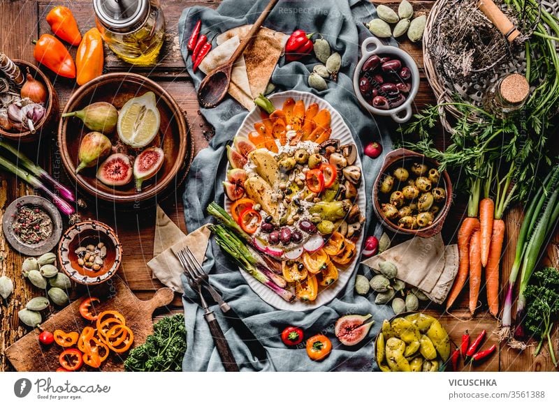 Schmackhafte mediterrane Küche mit Hummus-Platte. Ramadan-Iftar-Abendessen. Verschiedene eingelegte und frische Gemüse: Oliven, Fide, grüne Mandeln. Veganes Party-Essen . Festliche Versammlung