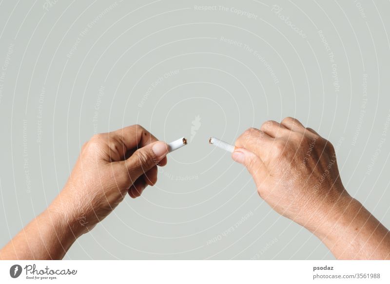 Raucherentwöhnung, kein Tabaktag, Mutterhände brechen die Zigarette Süchtige Erwachsener gealtert Anti Hintergrund schlecht gebrochen Pflege Kaukasier
