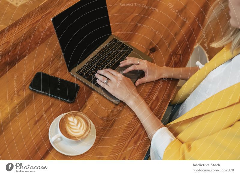 Erwachsene Frau trinkt aromatischen Kaffee, während sie im Café am Laptop arbeitet freiberuflich benutzend schäumen Internet Latte trinken Tasse heimwärts