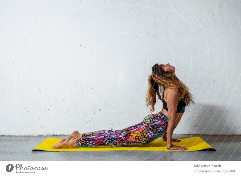 Frau praktiziert Yoga auf der Matte üben nach oben gerichtete Hundehaltung bhujangasana Unterlage Körperhaltung positionieren Gleichgewicht Augen geschlossen