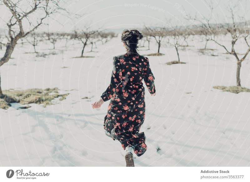 Fröhliche, modische Frau läuft auf Schnee Glück Spaß Winter Feld heiter trendy Natur Mode Stil jung Freude sich[Akk] entspannen Freiheit Landschaft aufgeregt