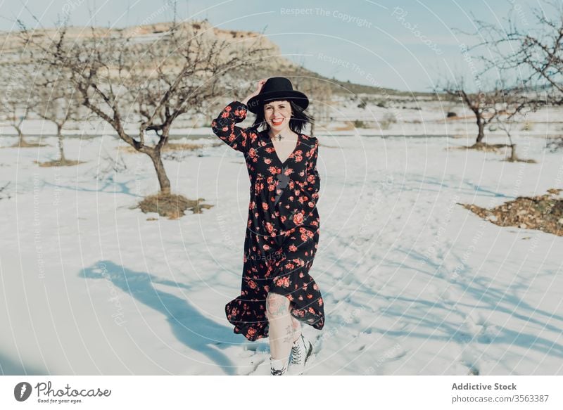 Selbstbewusste trendige Frau steht im verschneiten Feld Stil trendy selbstbewusst Schnee Natur attraktiv in die Kamera schauen modern Mode charmant farbenfroh
