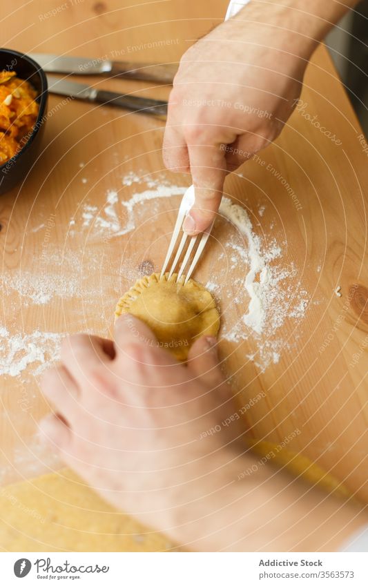 Erntehelfer macht Ravioli auf dem Tisch Presse Gabel Schalen & Schüsseln Teigwaren Person Koch Gebäck Mehl Prozess vorbereiten Küche Lebensmittel Messer