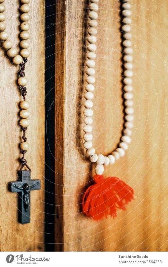Katholischer Rosenkranz und Kruzifix, die an einer Tür hängen Christentum Religion Kirche altehrwürdig Perlen katholisch Glaube Gebet Holz Schnitzereien