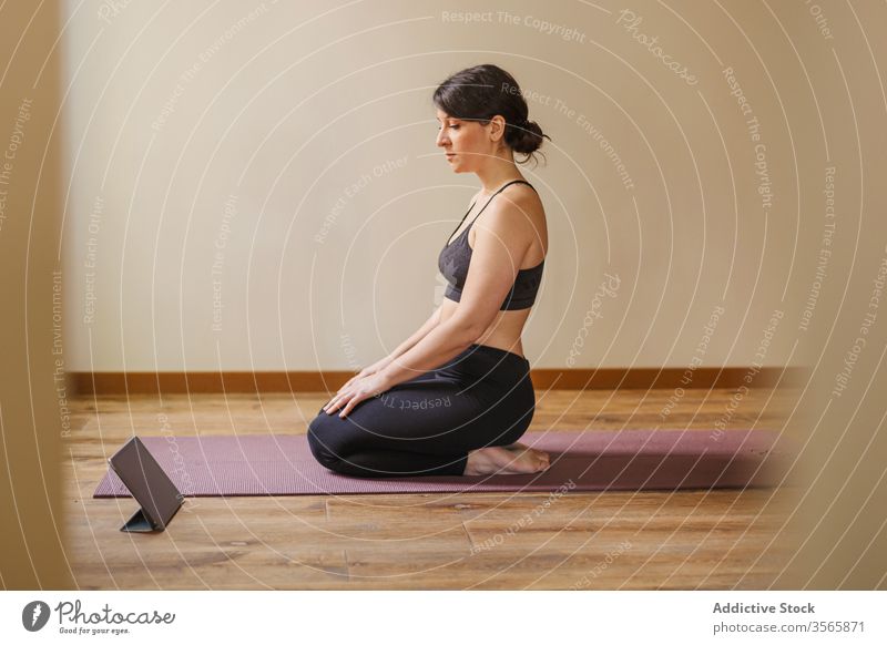 Frau nimmt Tablette während der Pause von der Yogapraxis zu Hause heimwärts üben Unterlage Tutorial ruhen online Touchscreen Sportbekleidung Gesunder Lebensstil