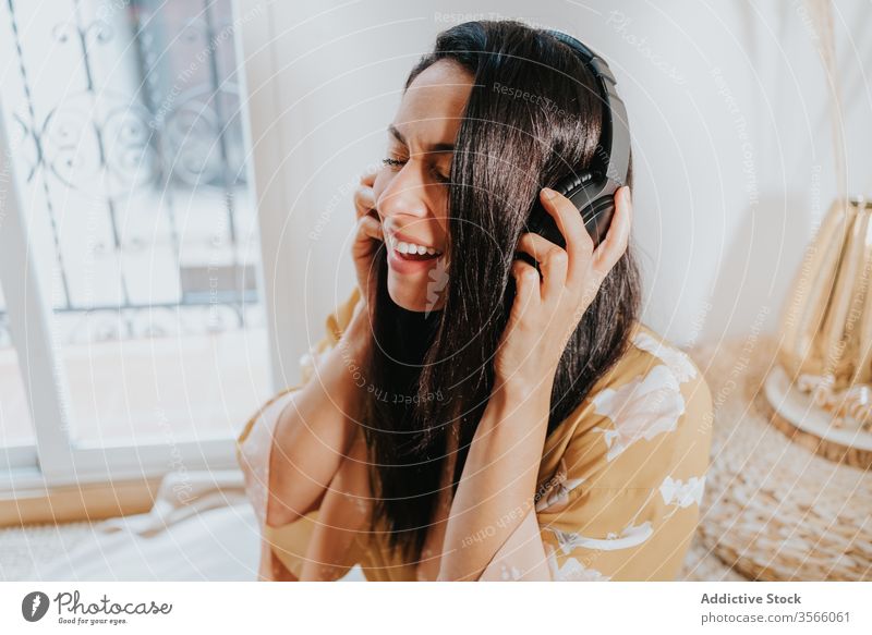 Glückliche Frau mit Kopfhörern, die zu Hause Musik hört Raum Gesang zuhören Kälte genießen Komfort räkeln Schlafzimmer sich[Akk] entspannen Lifestyle ruhen