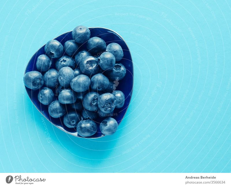 Schmackhafte Bio-Blaubeeren auf blauem Papierhintergrund organisch Antioxidantien Entzug Draufsicht nass Saft Gesundheit Vitamin Ernährung Diät Haufen