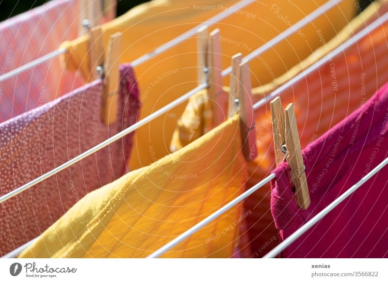 Sommerwäsche - Kleidung in gelb und rosa hängt auf dem Kleiderständer Wäsche Wäscheklammer trocknen Wäscheleine Waschtag Haushalt Bekleidung Sauberkeit