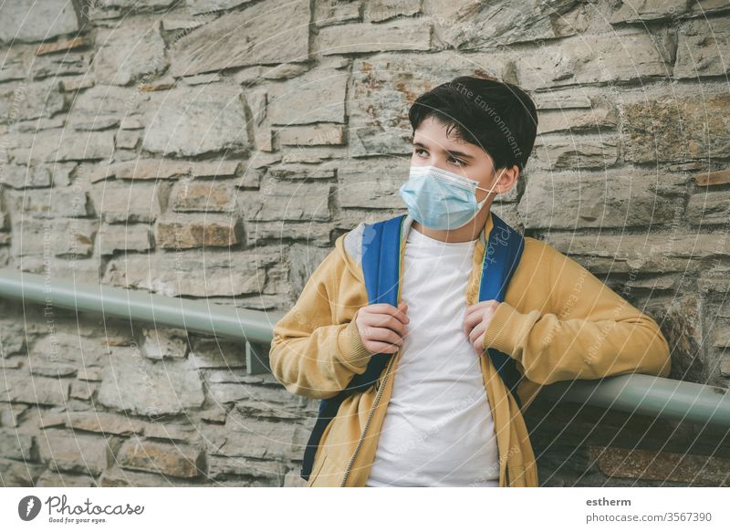 Kind mit medizinischer Maske und Rucksack wartet an der Schultür Coronavirus Virus Seuche covid-19 Schule schuler Pandemie Quarantäne zurück zur Schule