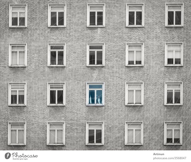 Glasfenster einer Wolkenkratzerwohnung oder eines Hotelgebäudes. Äußere Ziegelwand eines Wohngebäudes. Entwurf der Architektur. Fenster der Gebäudetextur Hintergrund. Grau-weißes Vintage-Gebäude.