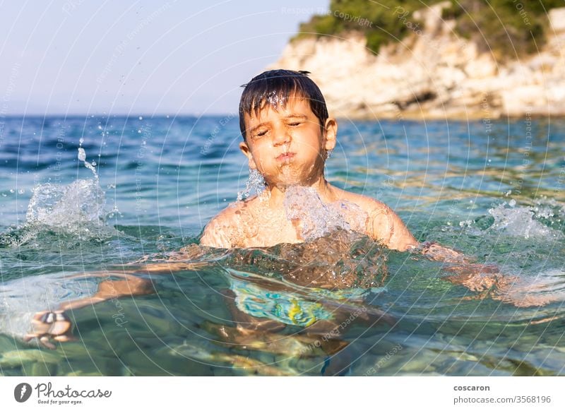 Kleines Kind mit Spaß ins Meer aktiv Baby Strand schön blau Junge Kaukasier Kindheit niedlich Tropfen dynamisch Energie Gesicht Fröhlichkeit Glück