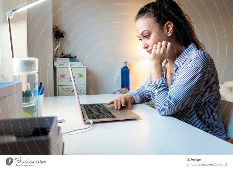 Seitenansicht einer jungen Frau, die zu Hause mit einem Laptop arbeitet Person Business Geschäftsfrau Computer Technik & Technologie Erwachsener studierend