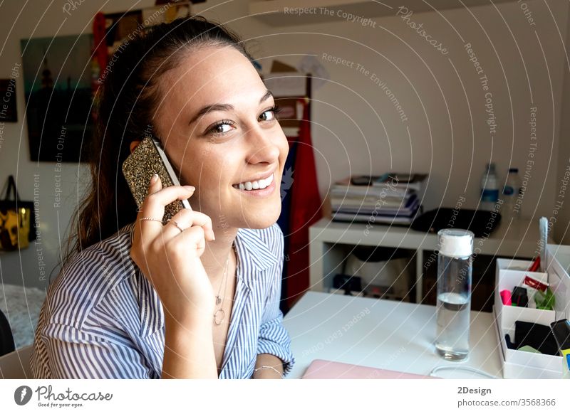Lächelnde Frau mit einem Telefongespräch zu Hause Mitteilung Erwachsener Person Schreibtisch Handy Technik & Technologie Business im Innenbereich Sitzen