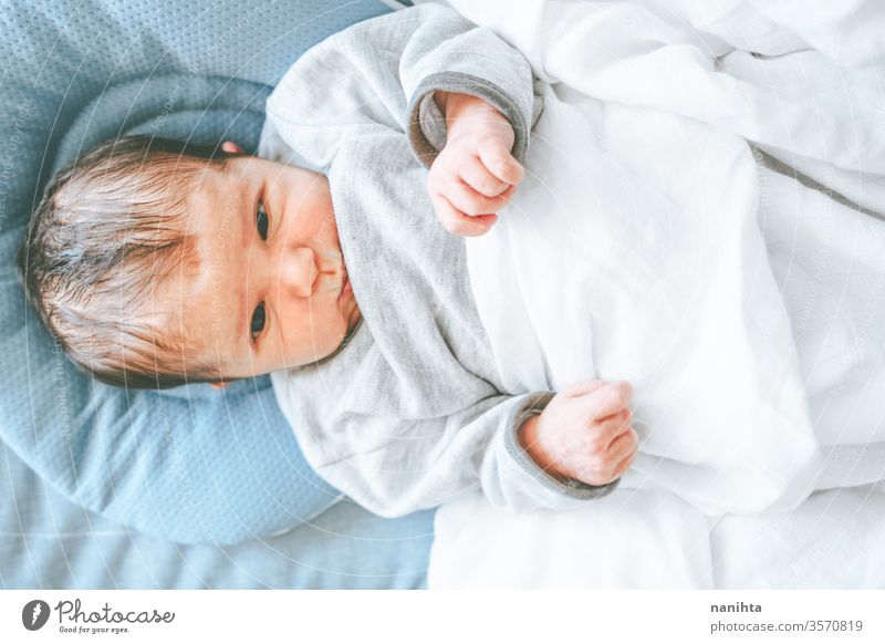 Kleines neugeborenes Mädchen, das sich hinlegt und versucht, sich zu entspannen Baby Neugeborene Geburt erster Tag Junge Mama Familie Glück Fröhlichkeit Pflege