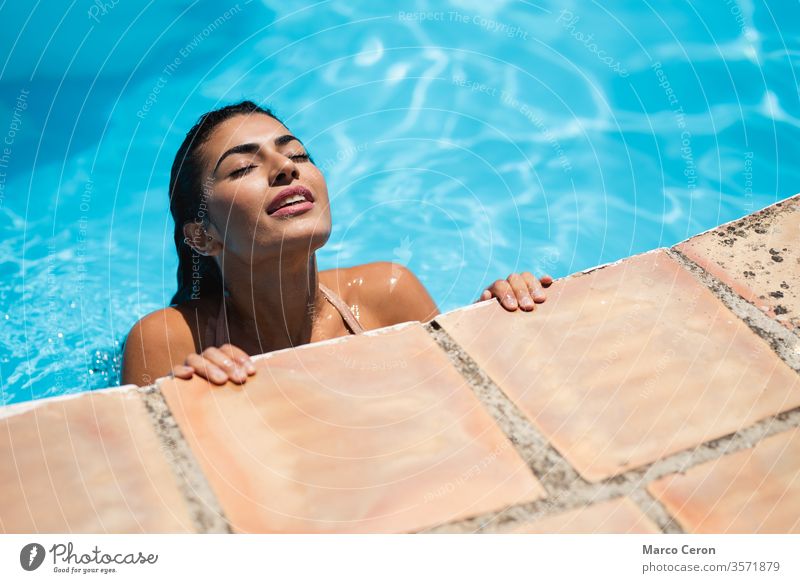 Junge Frau mit gemischtem Rennen entspannt sich im Wasser im Schwimmbad gemischte Rasse schön jung attraktiv Pool Bikini Bräune Haut Mädchen Sonnenbad Urlaub