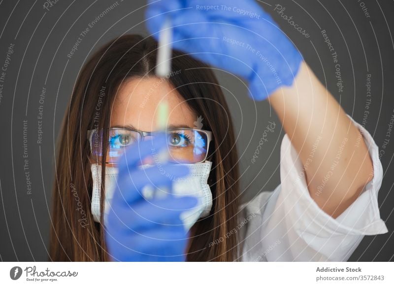 Frau benutzt Spritze während der COVID 19-Pandemie Coronavirus Mundschutz Diagnostik Handschuh behüten Arzt Sicherheit Risiko Krankheit Krankenpfleger ernst