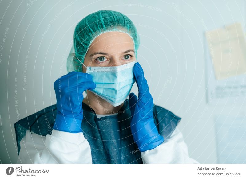 Ärztin mit Schutzmaske und Schutzbrille Mundschutz medizinisch behüten Coronavirus COVID Frau Krankenpfleger Arzt Sicherheit Sanitäter anhaben angezogen Uniform