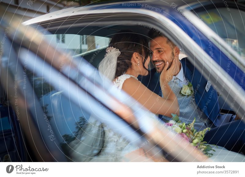 Erfreutes frisch vermähltes Paar in Luxuswagen Jungvermählter PKW Braut striegeln Brautkleid Hochzeit Reichtum stilvoll Anzug Glück Freude Lächeln heiter Inhalt