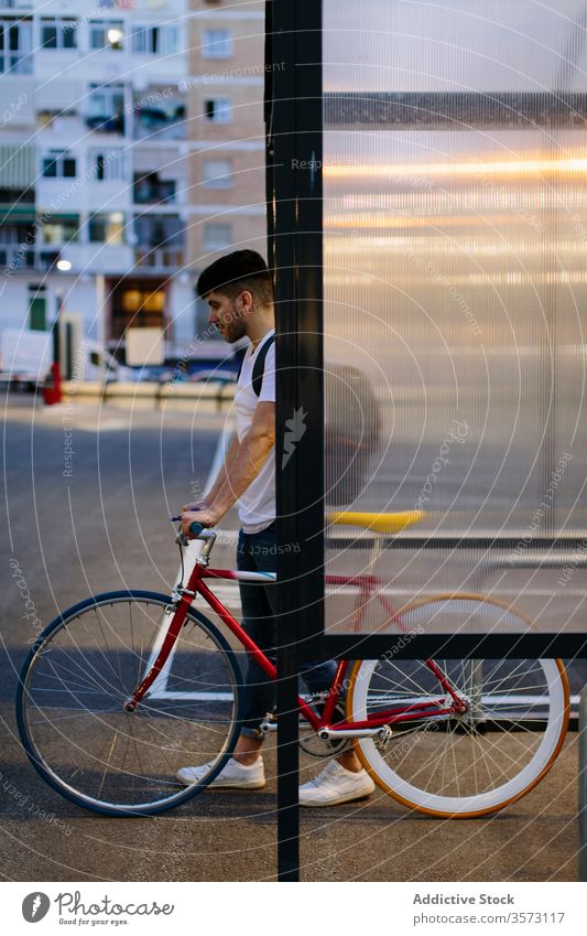 Mann steigt mit einem Fahrrad aus einem Parkplatz aus Fixie Zyklus urban Rad feststehend Sport Transport Ausrüstung Lifestyle Wand Straße Hipster