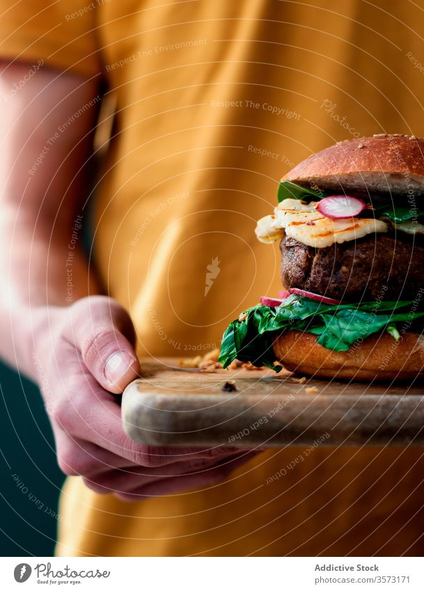 Anonyme Person mit leckerem veganen Linsen-Burger Feinschmecker Hände Veganer Gemüse-Burger Fastfood Essen Halt gebacken natürlich Lifestyle organisch Spinat