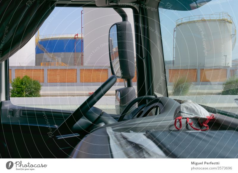 Lkw-Innenraum, Armaturenbrett mit einer Maske und Kraftstofftanks im Hintergrund Lastwagen Kraftstoffe Lager Rückansicht Einlagen Lenkrad Verkehr Mundschutz