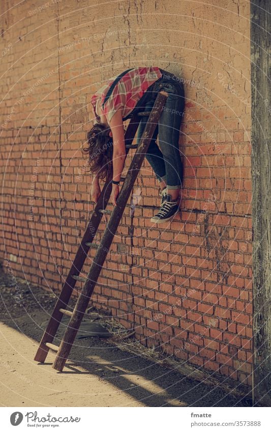 Frau hängt über einer Leiter Wand hängen frau hängend Depression faulenzen Verzweiflung Krise entspannung Faulheit entspannend Karriere karriereleiter